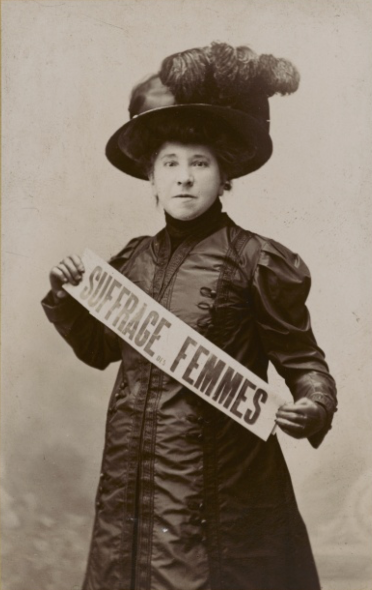 Hubertine Auclert tenant une banderole concernant le suffrage des femmes
